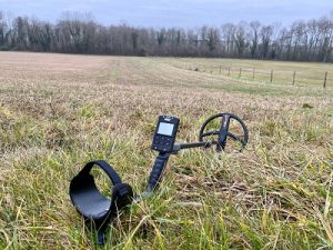 detectoriste avec un deus II posé sur l'herbe dans un près