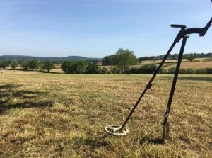 image d'un prospecteur avec son détecteur de métaux dans un près, en suisse
