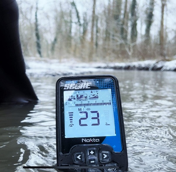 prospecteur qui utilise le mode discrimination au lien d'utiliser le mode tous métaux pour détecter dans une rivière avec un Nokta double score