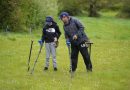 un père et sa fille détectent dans une prairie